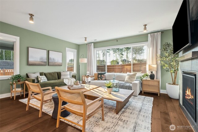15306 204th Ave E Unit 23, Bonney Lake, WA 98391 - living area with a warm lit fireplace, healthy amount of natural light, baseboards, and dark wood-style flooring