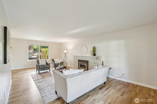 7309 134th Ave NE, Redmond, WA 98052 - living room with light wood-style flooring, a brick fireplace, and baseboards