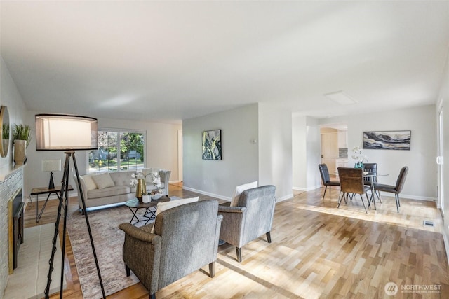 7309 134th Ave NE, Redmond, WA 98052 - living room with light wood-style flooring, baseboards, and a glass covered fireplace