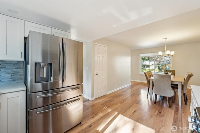 7309 134th Ave NE, Redmond, WA 98052 - dining space featuring a chandelier, light wood-style floors, and baseboards