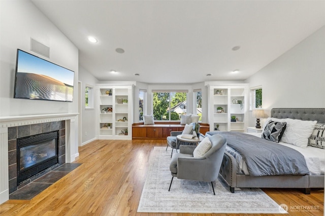 7309 134th Ave NE, Redmond, WA 98052 - bedroom with a tile fireplace, light wood-type flooring, and recessed lighting