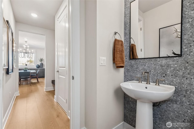 15310 204th Ave E Unit 22, Bonney Lake, WA 98391 - bathroom featuring wood finished floors, a chandelier, backsplash, and baseboards