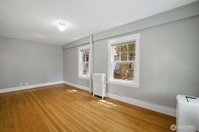 2132 5th Ave Unit 209, Seattle, WA 98121 - empty room featuring radiator, baseboards, and light wood-style flooring