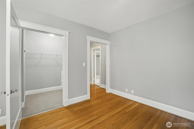 2132 5th Ave Unit 209, Seattle, WA 98121 - unfurnished bedroom with baseboards, wood finished floors, and a closet