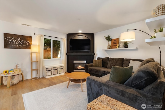 2629 123rd Pl SW Unit A, Everett, WA 98204 - living room featuring wood finished floors, a glass covered fireplace, baseboards, and recessed lighting