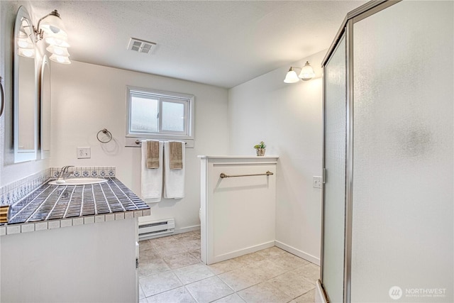 27 Poplar Ave, Wenatchee, WA 98801 - bathroom with a baseboard heating unit, toilet, vanity, a shower stall, and tile patterned floors
