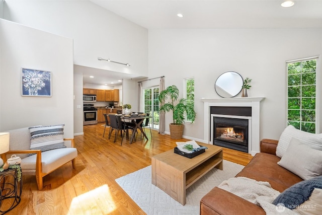 78 Honeycomb Ln, Bellingham, WA 98229 - living room featuring a glass covered fireplace, light wood finished floors, high vaulted ceiling, and recessed lighting