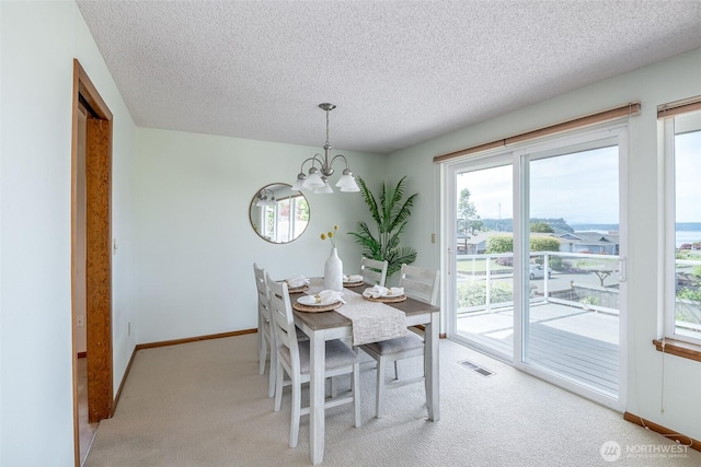 7215 N 23rd, Tacoma, WA 98406 - dining space featuring a chandelier, light colored carpet, a textured ceiling, and healthy amount of natural light
