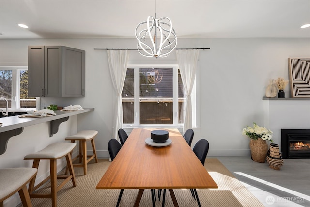 4642 Eastern Ave N, Seattle, WA 98103 - dining space featuring a chandelier, a warm lit fireplace, and recessed lighting