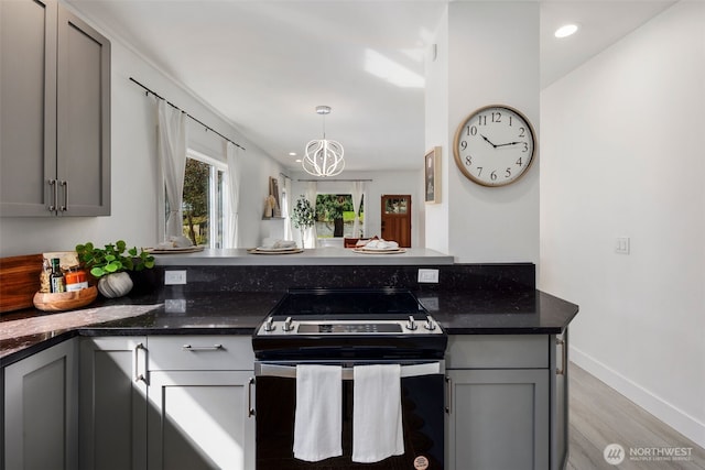 4642 Eastern Ave N, Seattle, WA 98103 - kitchen with electric stove, gray cabinetry, light wood finished floors, a chandelier, and a peninsula