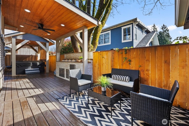 4642 Eastern Ave N, Seattle, WA 98103 - wooden deck featuring a hot tub, a fenced backyard, a ceiling fan, and outdoor lounge area