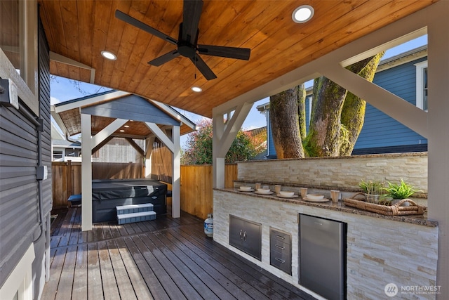 4642 Eastern Ave N, Seattle, WA 98103 - wooden deck featuring a covered hot tub, area for grilling, a fenced backyard, and ceiling fan