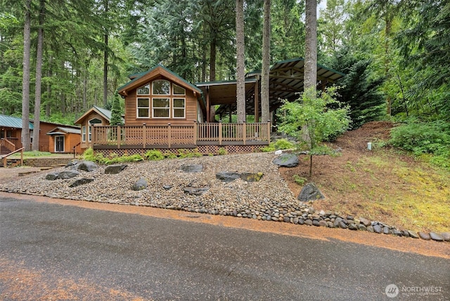 1546 Reservation Rd SE Unit 116, Olympia, WA 98513 - rustic home featuring a wooden deck, an outdoor structure, and a carport