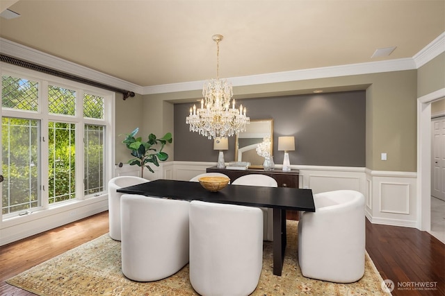 20450 NE 71st St, Redmond, WA 98053 - dining space with a chandelier, crown molding, wood finished floors, a wainscoted wall, and a decorative wall