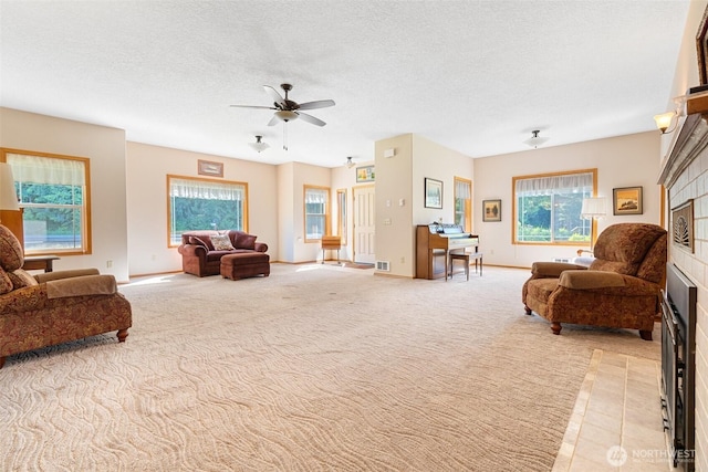 735 Coal Creek Rd, Chehalis, WA 98532 - living room with a ceiling fan, light carpet, a fireplace with flush hearth, baseboards, and a textured ceiling