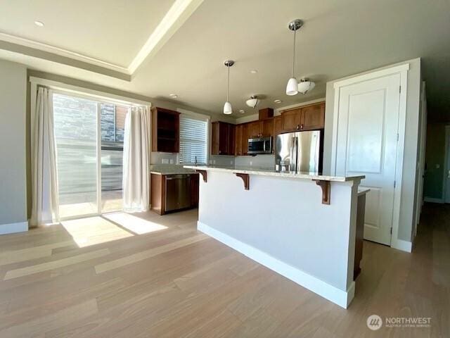 5105 Grand Loop Unit 107, Tacoma, WA 98407 - kitchen featuring appliances with stainless steel finishes, plenty of natural light, a breakfast bar, and light countertops