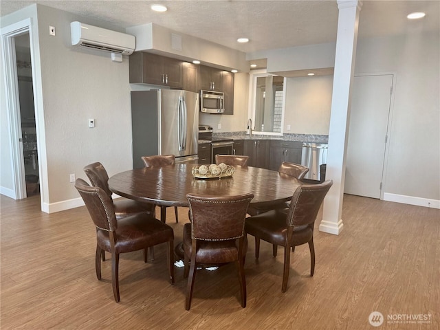 5105 Grand Loop Unit 107, Tacoma, WA 98407 - dining space with a wall mounted AC, baseboards, light wood-type flooring, decorative columns, and recessed lighting