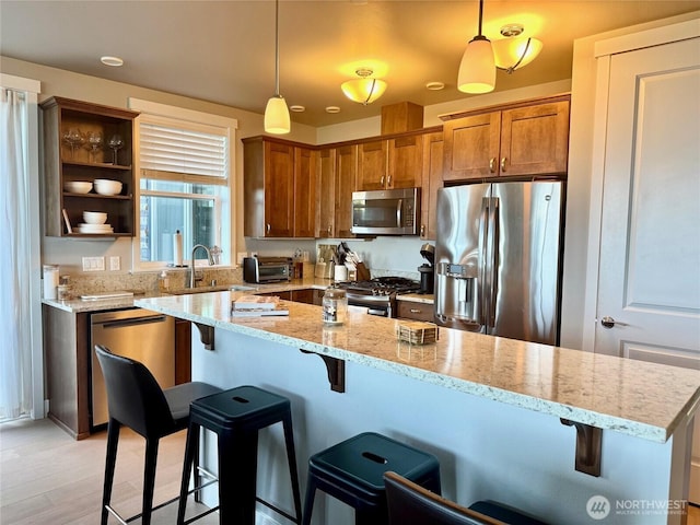 5105 Grand Loop Unit 107, Tacoma, WA 98407 - kitchen featuring appliances with stainless steel finishes, a sink, hanging light fixtures, and a kitchen bar