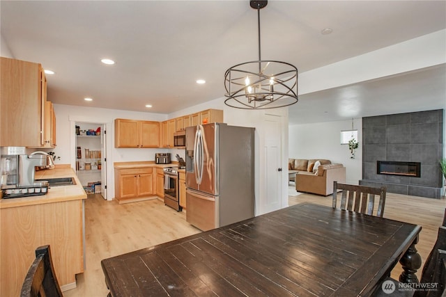 1860 Hoffman Hill Blvd, Dupont, WA 98327 - kitchen with appliances with stainless steel finishes, a sink, light brown cabinetry, light countertops, and light wood-style flooring