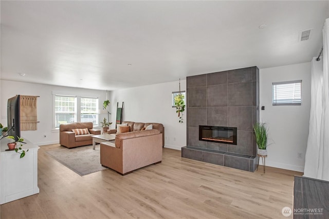 1860 Hoffman Hill Blvd, Dupont, WA 98327 - living area featuring light wood finished floors, a tile fireplace, and baseboards