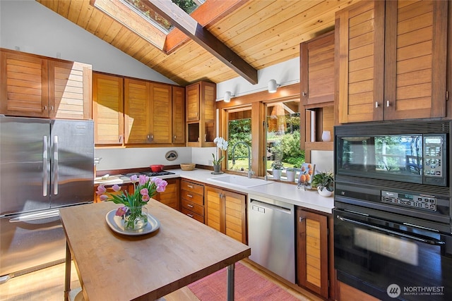 9767 Battle Point Dr NE, Bainbridge Island, WA 98110 - kitchen with black appliances, a skylight, light countertops, wood ceiling, and brown cabinetry