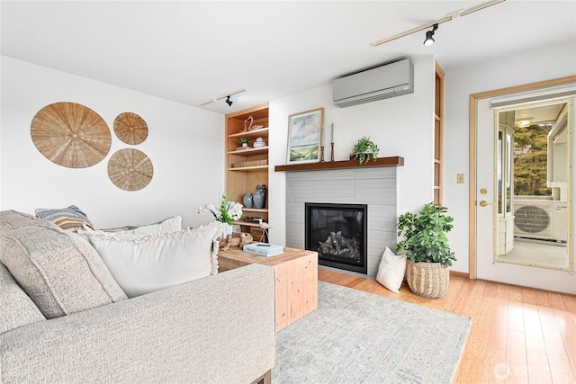 912 11th Unit 101, Bellingham, WA 98225 - living area featuring track lighting, a wall unit AC, wood finished floors, and a fireplace