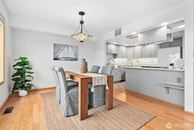 912 11th Unit 101, Bellingham, WA 98225 - dining space featuring light wood-style flooring, a chandelier, baseboards, and recessed lighting