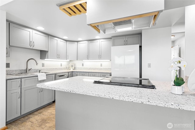 912 11th Unit 101, Bellingham, WA 98225 - kitchen featuring gray cabinetry, white refrigerator, a sink, light stone counters, and recessed lighting