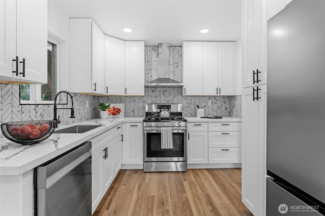 638 SW 299th Pl, Federal Way, WA 98023 - kitchen with stainless steel appliances, wall chimney exhaust hood, white cabinetry, light wood-style flooring, and recessed lighting