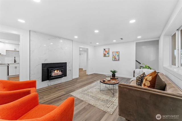 638 SW 299th Pl, Federal Way, WA 98023 - living area featuring light wood-style flooring, recessed lighting, a high end fireplace, and stairs