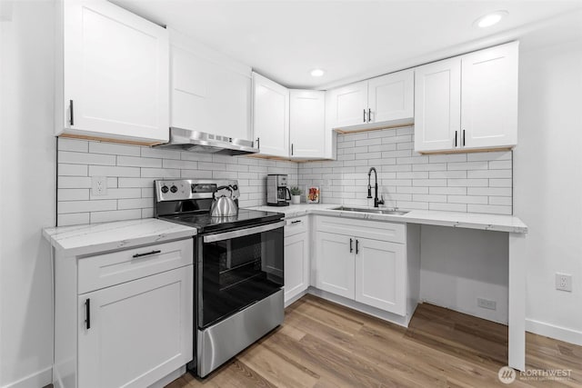 638 SW 299th Pl, Federal Way, WA 98023 - kitchen featuring stainless steel electric range, under cabinet range hood, white cabinetry, decorative backsplash, and light wood-style floors