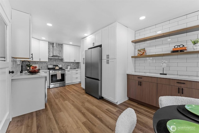 638 SW 299th Pl, Federal Way, WA 98023 - kitchen with appliances with stainless steel finishes, wall chimney exhaust hood, backsplash, light countertops, and white cabinets