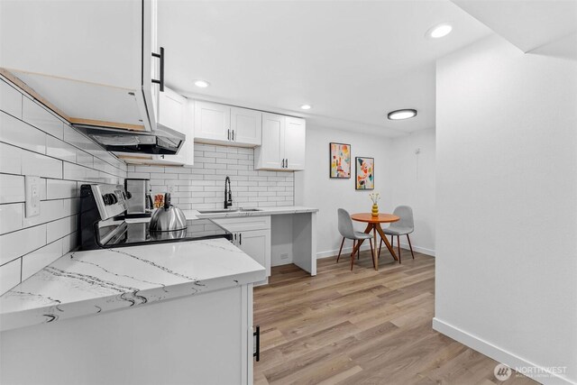 638 SW 299th Pl, Federal Way, WA 98023 - kitchen with white cabinets, tasteful backsplash, electric range oven, light wood finished floors, and light stone counters