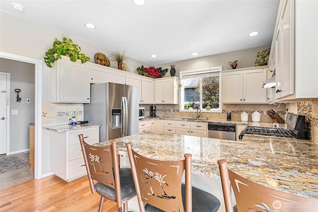 1521 Westview Pl, Lynden, WA 98264 - kitchen with appliances with stainless steel finishes, a sink, ventilation hood, backsplash, and a peninsula