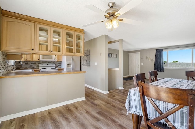 907 S Balsam St, Moses Lake, WA 98837 - kitchen featuring white appliances, a sink, glass insert cabinets, wood finished floors, and tasteful backsplash