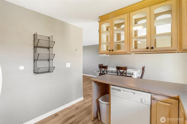 907 S Balsam St, Moses Lake, WA 98837 - kitchen featuring white dishwasher, light wood finished floors, baseboards, light brown cabinets, and glass insert cabinets