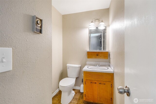 907 S Balsam St, Moses Lake, WA 98837 - half bathroom featuring toilet, vanity, tile patterned flooring, and baseboards