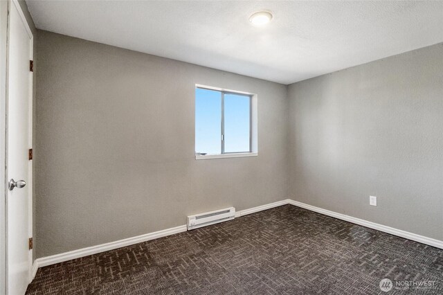 907 S Balsam St, Moses Lake, WA 98837 - spare room with a baseboard radiator, dark colored carpet, and baseboards
