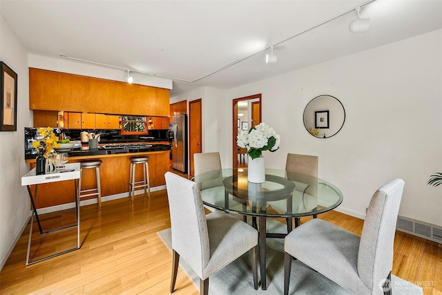 718 N 59th St, Seattle, WA 98103 - dining space featuring track lighting, light wood finished floors, and baseboards