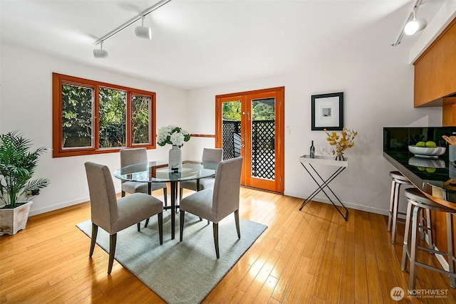 718 N 59th St, Seattle, WA 98103 - dining space with rail lighting, light wood-type flooring, and baseboards