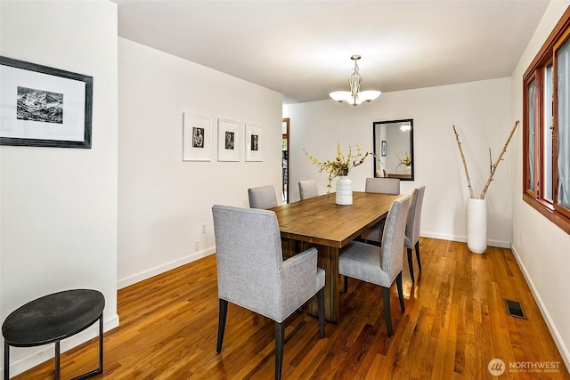 718 N 59th St, Seattle, WA 98103 - dining area with wood finished floors, baseboards, and a chandelier