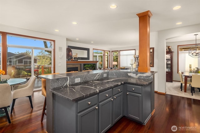 5613 21st Ave SW, Seattle, WA 98106 - kitchen with dark wood finished floors, gray cabinets, dark stone counters, recessed lighting, and a warm lit fireplace