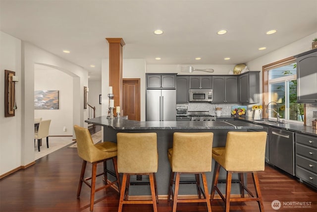 5613 21st Ave SW, Seattle, WA 98106 - kitchen with stainless steel appliances, tasteful backsplash, a breakfast bar, recessed lighting, and dark wood-type flooring