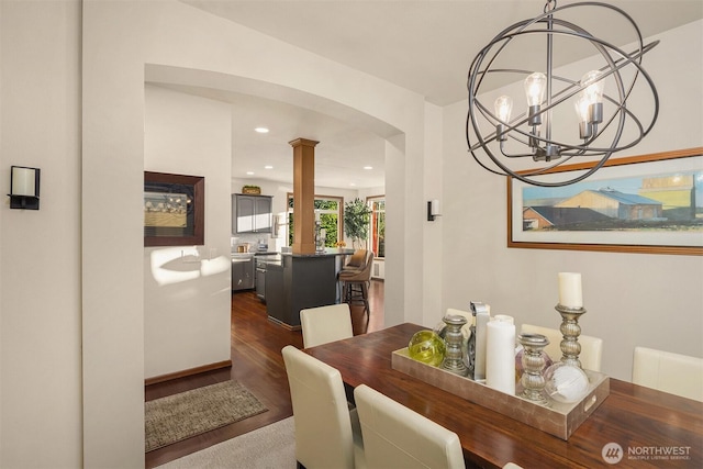 5613 21st Ave SW, Seattle, WA 98106 - dining room featuring arched walkways, dark wood-type flooring, ornate columns, a chandelier, and recessed lighting