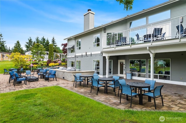 1427 100th St SW Unit 145, Everett, WA 98204 - back of property featuring a balcony, a patio area, a chimney, and a yard