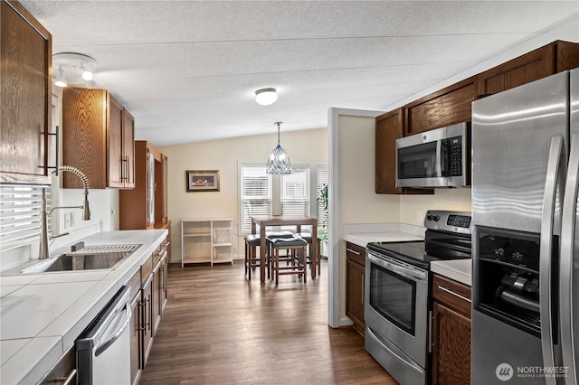 1427 100th St SW Unit 145, Everett, WA 98204 - kitchen with stainless steel appliances, a sink, lofted ceiling, dark wood finished floors, and pendant lighting