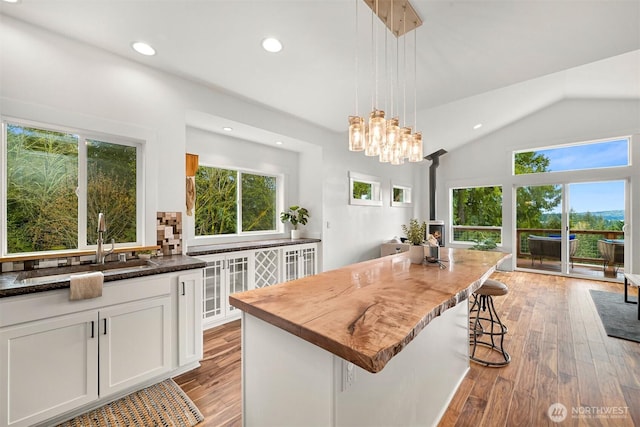 104 Grand View Ln, Bellingham, WA 98229 - kitchen featuring healthy amount of natural light, light wood-style floors, decorative backsplash, white cabinets, and vaulted ceiling