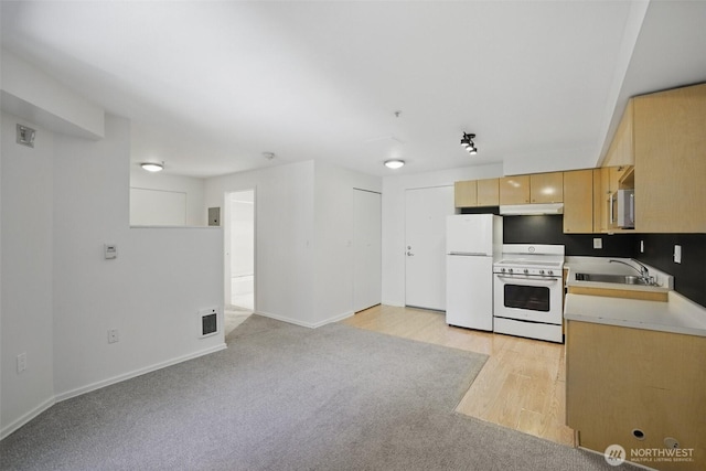 425 Vine St Unit 513, Seattle, WA 98121 - kitchen featuring white appliances, under cabinet range hood, a sink, light brown cabinetry, and light countertops