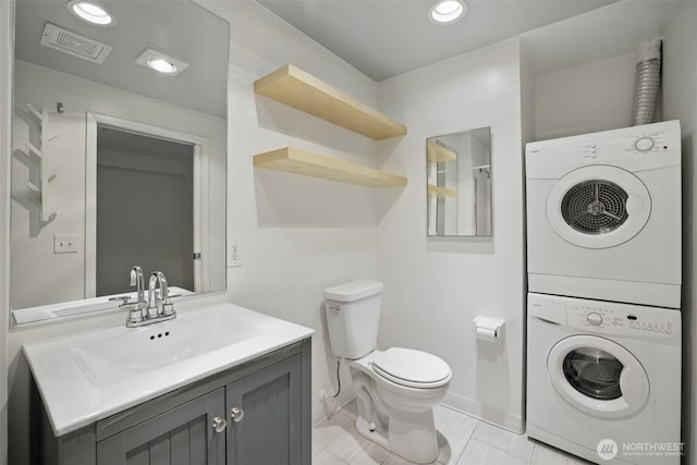 425 Vine St Unit 513, Seattle, WA 98121 - bathroom featuring stacked washing machine and dryer, toilet, vanity, recessed lighting, and tile patterned floors