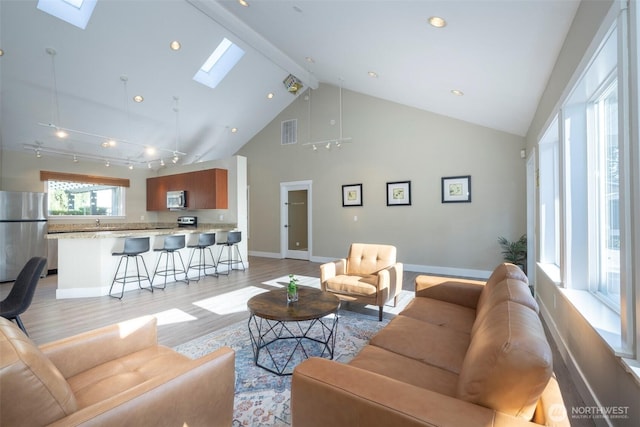 11215 NE 128th St Unit L-203, Kirkland, WA 98034 - living area with a skylight, light wood-type flooring, baseboards, and high vaulted ceiling